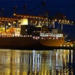 Container ship loaded with cargo at illuminated port during nighttime