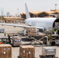 Daytime cargo airplane loading crates and pallets on tarmac for air freight to Saudi Arabia